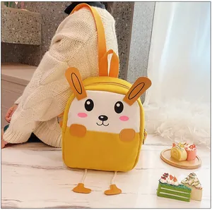Détail d'un sac à dos lapin en toile jaune pour enfant avec oreilles 3D et visage