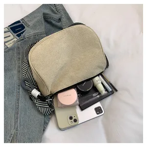 Detail of corduroy crossbody bag showing large capacity for cosmetics and accessories