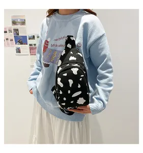 Canvas chest bag with black and white cow print and adjustable strap for casual wear