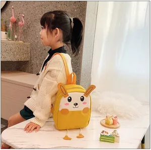 Détail du sac à dos cartoon en toile jaune avec oreilles 3D et jambes sur un enfant