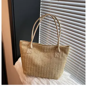 Dettaglio della borsa tote in paglia intrecciata con manici in PU rinforzati per l'estate