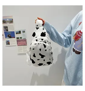 Detail of canvas chest bag with black and white cow print and adjustable shoulder strap