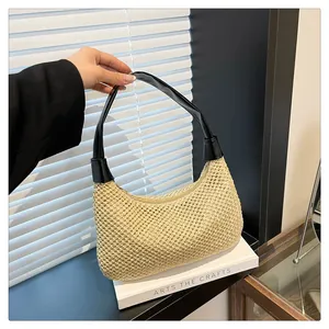 Detail der gewebten Stroh-Tasche mit schwarzem Ledergriff und Reißverschluss