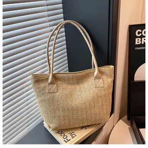 Dettaglio della trama a spina di pesce intrecciata di una grande borsa in paglia