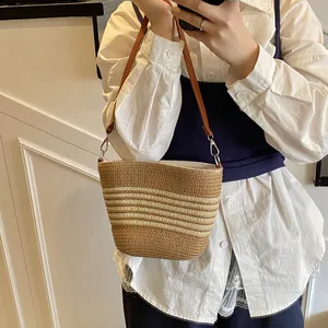 Sac seau en paille rayé avec bandoulière en cuir marron pour un look d'été chic