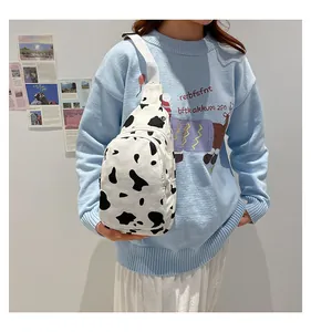 Detailed view of canvas cow print chest bag with adjustable strap worn by a model