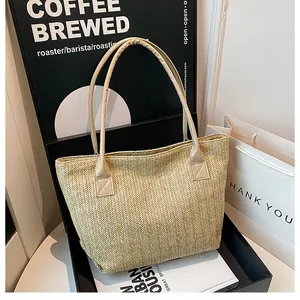 Dettaglio della borsa tote intrecciata beige con trama a spina di pesce e manici in pelle
