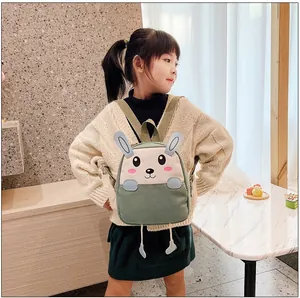 Détail du sac à dos lapin mignon avec oreilles 3D porté par un enfant, lumière douce