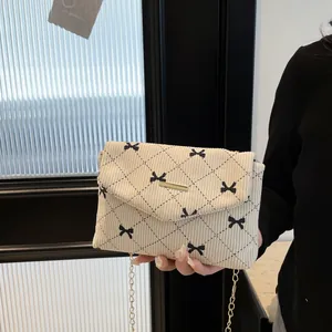 Borsa a tracolla in velluto beige con stampa fiocco nero e catena in metallo dorato