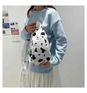 Close-up of cow print canvas chest bag worn by a model in a casual indoor setting