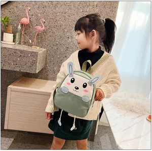 Détail du tissu en toile durable et des oreilles de lapin 3D sur le mini sac à dos vert