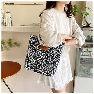 Detailansicht der Canvas-Tasche mit Leopardenmuster, Baumwollkordel-Griffen und Lederetikett