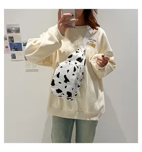 On-body view of a stylish cow print canvas chest bag with white adjustable strap