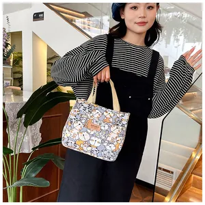 Detailweergave van canvas tas met kleurrijke kattenprint en lederen sportlabel