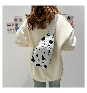Detail view of cow print canvas crossbody chest bag on a model for daily use