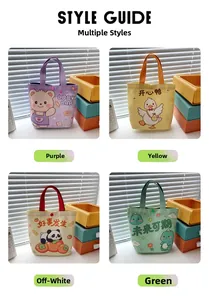 Detail of four colorful cartoon canvas tote bags with snap buttons in soft lighting