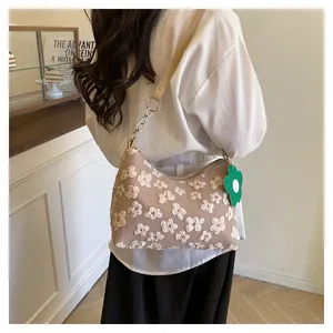Close-up of floral jacquard canvas bag with green flower charm and metal chain strap