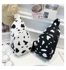 Close-up of canvas cow print chest bags featuring double zipper layers and nylon straps