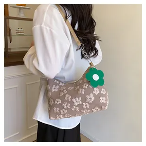 Detail of floral jacquard tote bag featuring premium leather strap and green flower charm