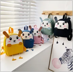 Détail de cinq mini sacs à dos en toile colorés avec oreilles de lapin 3D et visages mignons