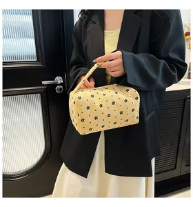 Detail of cream corduroy storage bag with black floral pattern and top handle