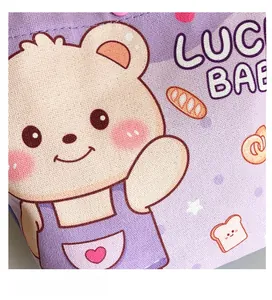 Macro detail of purple canvas tote bag featuring cute cartoon bear and lucky babe text