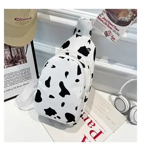 Detailed view of canvas cow print chest bag with dual zippers and adjustable strap