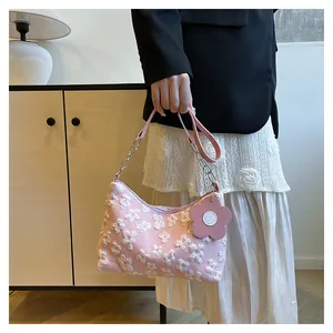 Detail of pink canvas tote featuring 3D floral embroidery and metal chain strap