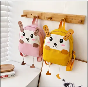 Détail des sacs à dos lapin rose et jaune avec de longues oreilles et des pieds en 3D