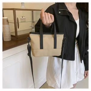 Détails d'un mini sac cabas en nylon kaki avec poignées noires et bandoulière