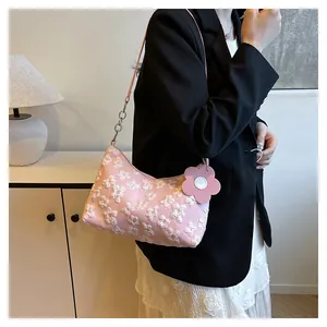 Detail of pink canvas tote with 3D flower texture and metal chain shoulder strap