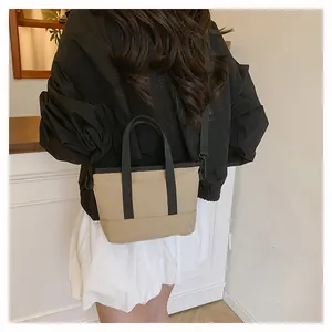 Détail du mini cabas kaki avec poignées noires et bandoulière amovible réglable