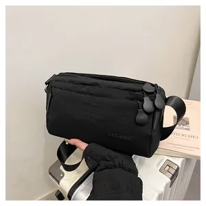 Détail du sac bandoulière tactique noir avec poches zippées et broderie de la marque