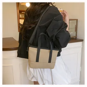 Détail du mini sac cabas kaki avec bandoulière noire porté par un mannequin en mode