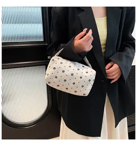Detailed texture of off-white corduroy pouch with black floral print and soft carry handle