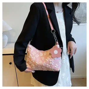 Detail of pink canvas bag with 3D white flower embroidery and floral charm accessory