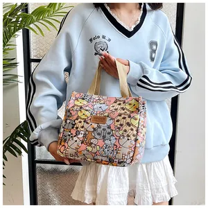 Detail van roze canvas tas met kattenpatronen en lederen patch op het handvat