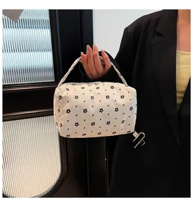 Detail of corduroy makeup bag with daisy floral pattern and sturdy carrying handle