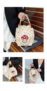 Close-up of cream canvas bucket bag featuring red mushroom print and woven handle details