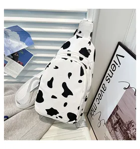 Detail of cow print canvas chest bag with zipper pockets and adjustable white strap