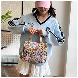 Detailweergave van de roze canvas tas met kattenpatronen en bruin SPORT-etiket