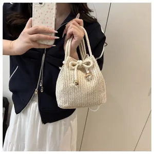 Close-up of straw bucket bag with V-shaped weave, drawstring closure and gold beads