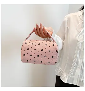 Detail of pink corduroy floral pouch with handle and zipper closure for storage