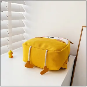 Vue détaillée du sac à dos en toile avec broderie animale et petites jambes 3D suspendues