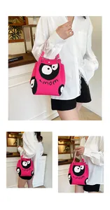 Detail of pink knitted tote bag with mom text, cartoon eyes, and woven handle