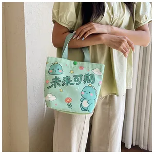 Detail of light green canvas tote with cartoon dinosaur print and snap button closure