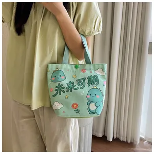 Detail of light green canvas bag with cute cartoon dinosaur and snap button closure