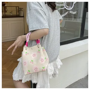 Detail of floral and cherry print knit tote bag with pink woven rope handle