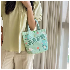 Detail of mint green canvas tote bag with cute dinosaur print and sturdy handles