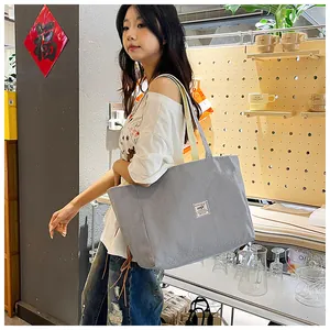Close-up of grey corduroy tote bag featuring a minimalist square fabric label design